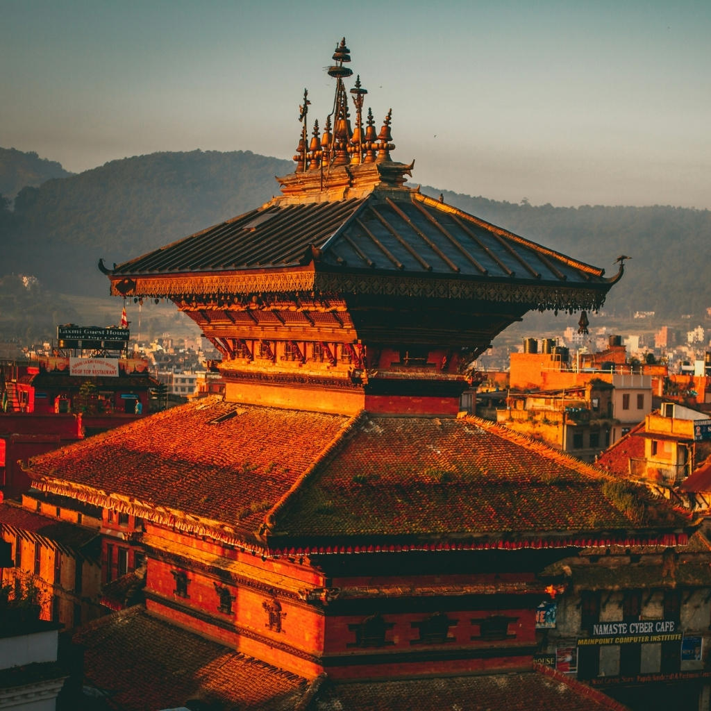 Ancient Nepalese temple with intricate architecture illuminated by sunset light in Kathmandu.