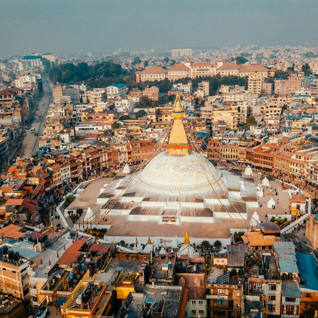 Golden Pagoda in Kathmandu, Nepal, surrounded by bustling city streets and traditional architecture.